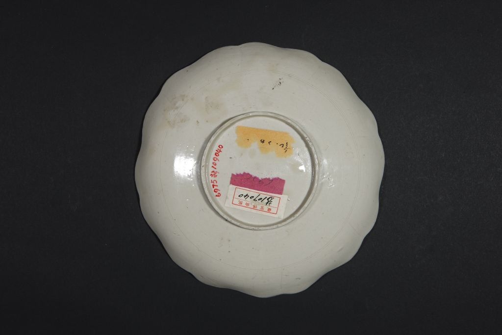 定窑白釉刻划朵花纹葵花式盘盘底